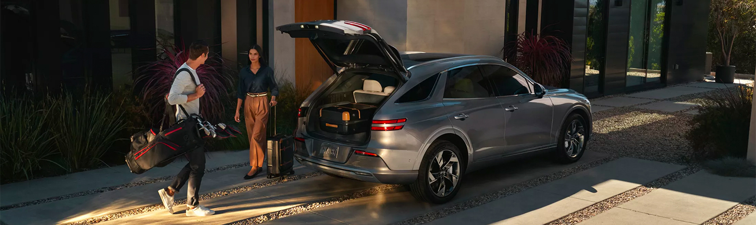 Happy couple loading up their Genesis SUV