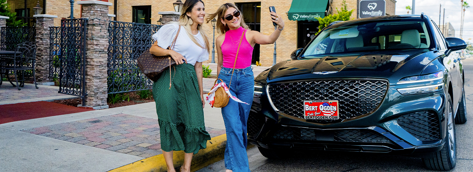 two girls taking a selfie in front of their new genesis