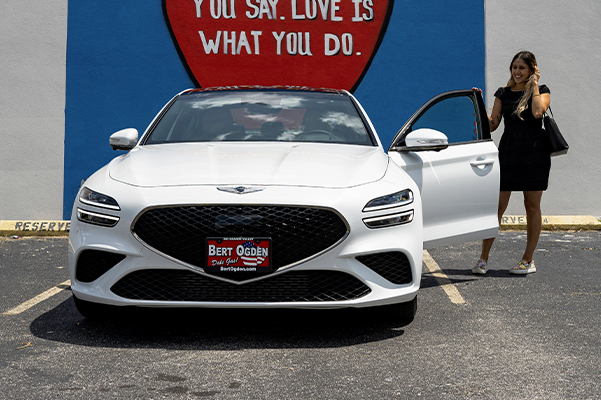 woman getting into her new white genesis