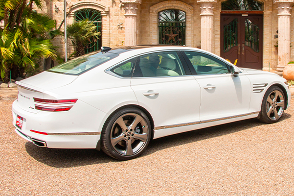 white genesis parked in front of palm trees