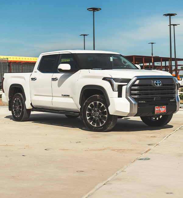 Side profile view of a Bert Ogden Toyota Truck parked in front of a construction site