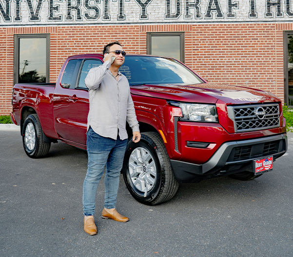happy customer standing outside his used nissan titan