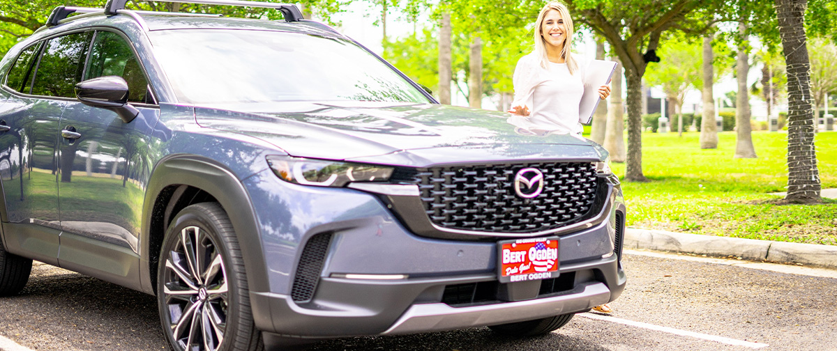 Woman standing beside her new 2023 Mazda CX-50