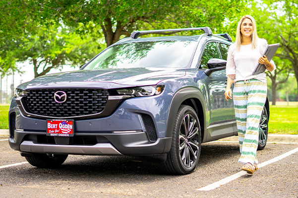 Woman walking beside her parked 2023 Mazda CX-50