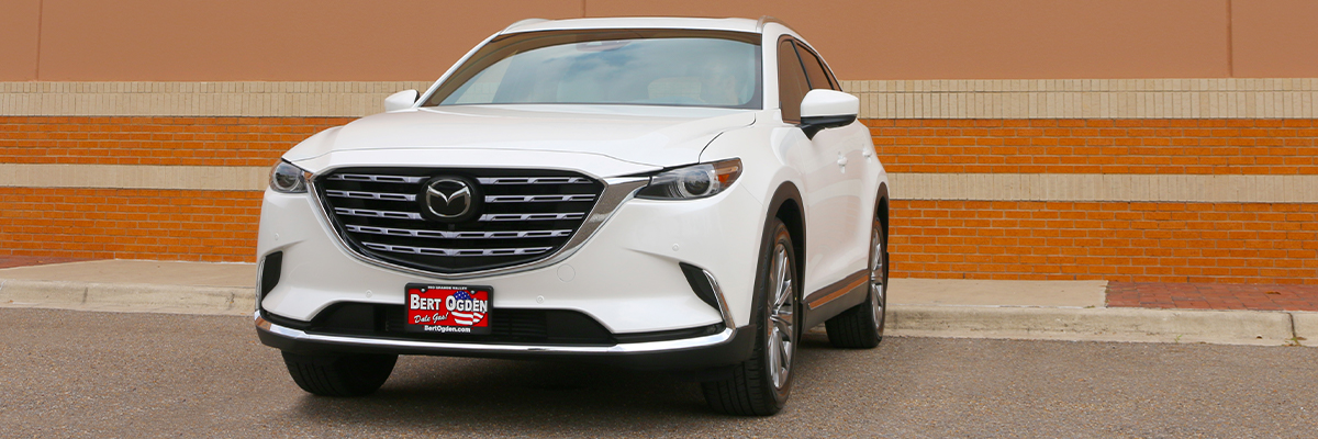white CX-9 parked in front of a building