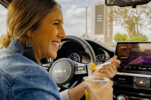 woman enjoying a snack in her new kia