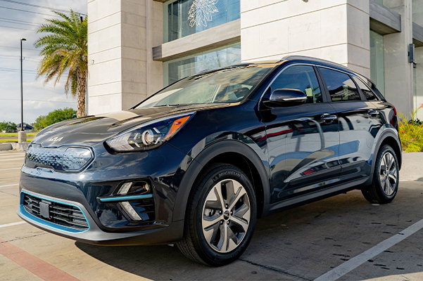 new kia parked in front of a building