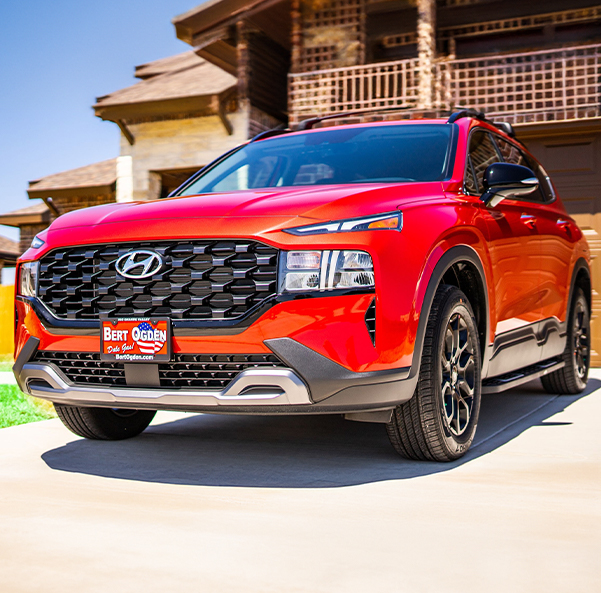Red Hyundai parked outside a house on a nice day