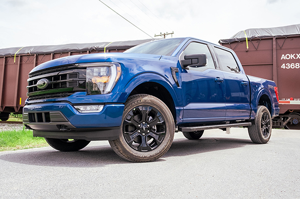 3/4 profile view of a Ford Truck in front of a train