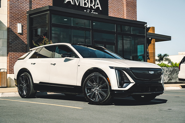 White Cadillac parked outside a modern building