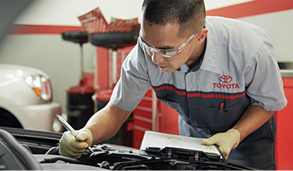 Toyota service tech checking an engine