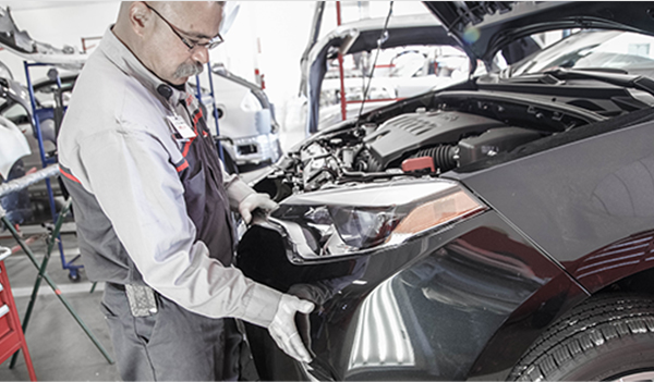 Toyota servicce tech fixing the bumper on a car