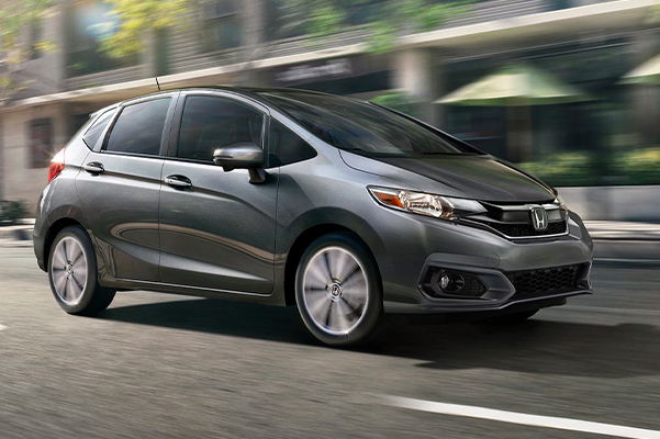 Front passenger-side view of the 2020 Honda Fit EX-L in Modern Steel Metallic driving on the road.